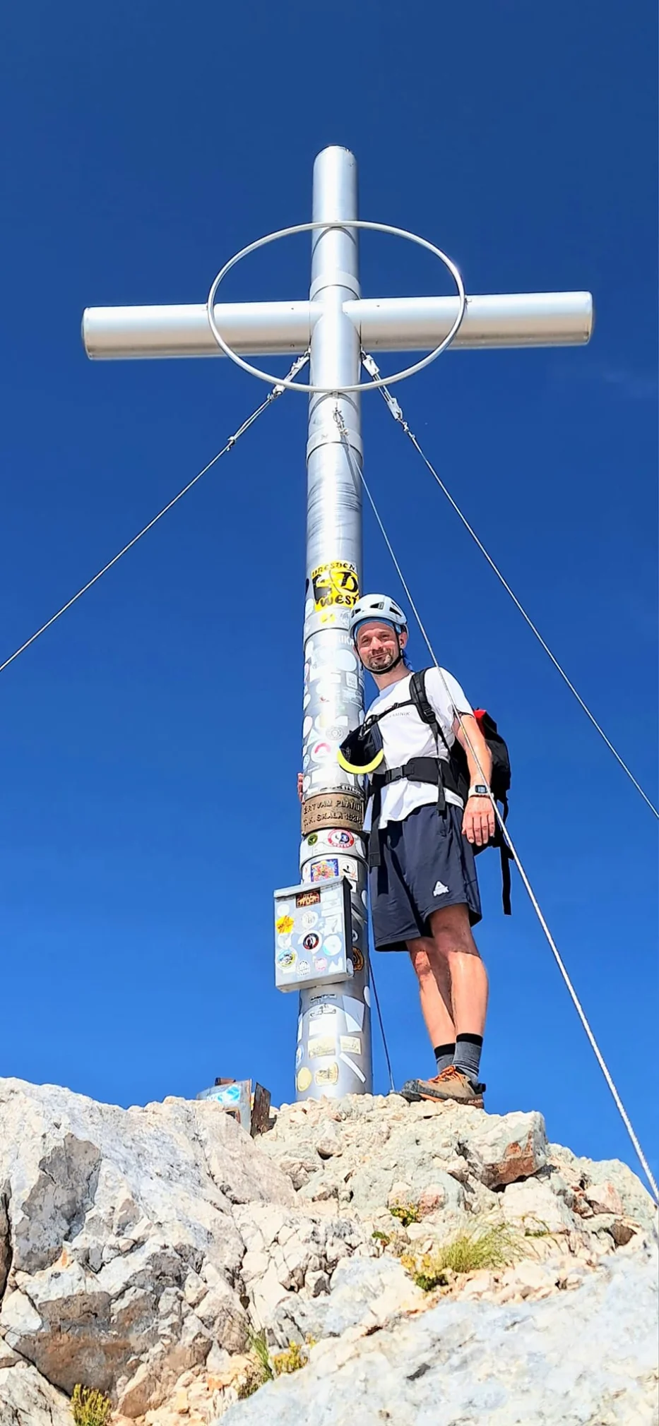 Standing next to the summit cross on Mount Škrlatica (2,740 m), 2nd highest mountain in Slovenia.