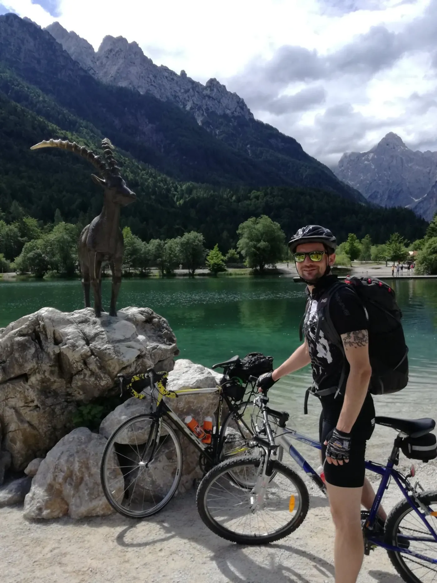 Ob jezeru Jasna pri Kranjski Gori z bronastim kozorogom in Julijskimi Alpami v ozadju